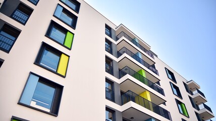 Contemporary residential building exterior in the daylight. Modern apartment buildings on a sunny day with a blue sky. Facade of a modern apartment building