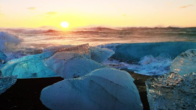 Broken icebergs on Okulsarlon Beach at sunset, slow motion close up