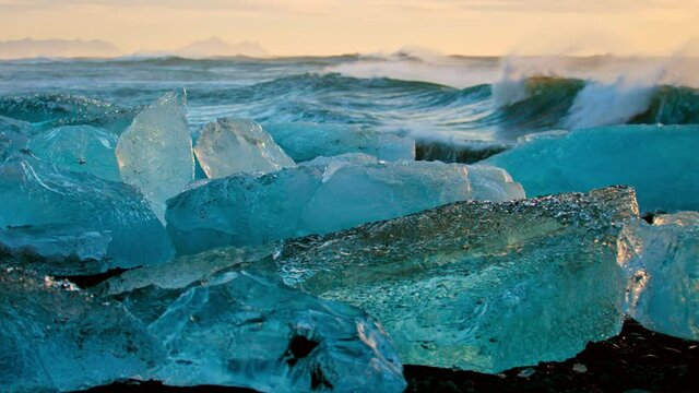 Close up, chunks of ice near ocean waves in slow motion