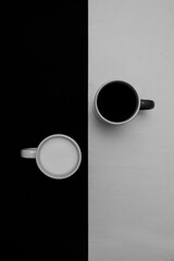 Yin and yang concept photography with two cups of milk and coffee
