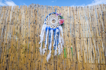 Vintage indigenous decoration hanging from a wall of old reeds, intense colors.