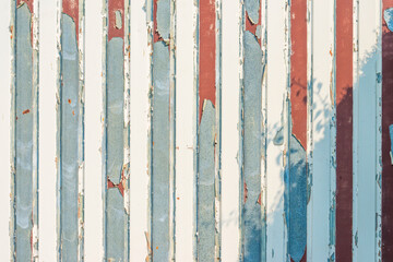 Detail of a steel garage door with peeling paint in sunlight as a decorative background, Voeren, Limburg, Belgium, September 13, 2020