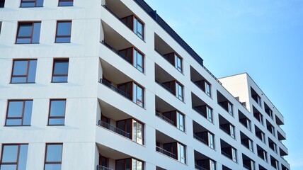 Contemporary residential building exterior in the daylight. Modern apartment buildings on a sunny day with a blue sky. Facade of a modern apartment building