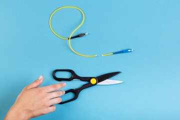 Destroy optical SC fiber by scissors. Isolated on blue