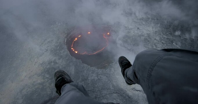 Person parachutes over active volcano, pov aerial