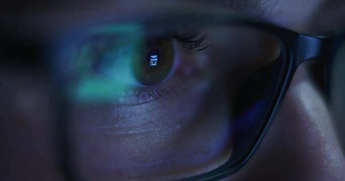 Macro of an Young Blond Successful Businesswoman with Glasses is Working with a Computer for Send Emails and Surf on a Web Browser at night.