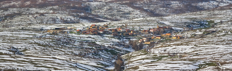 Panoramic view of mountainous town on a mountainside with snow in winter . Villayuste
