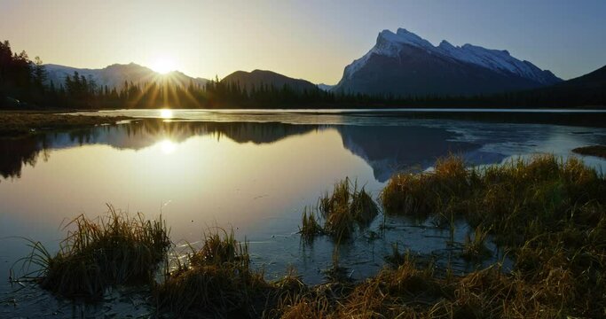 Sun sets over mountain lake in Banff National Park, wide