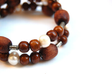 Macro photo of vintage handmade bracelet made of wood and natural white pearl isolated at white background.