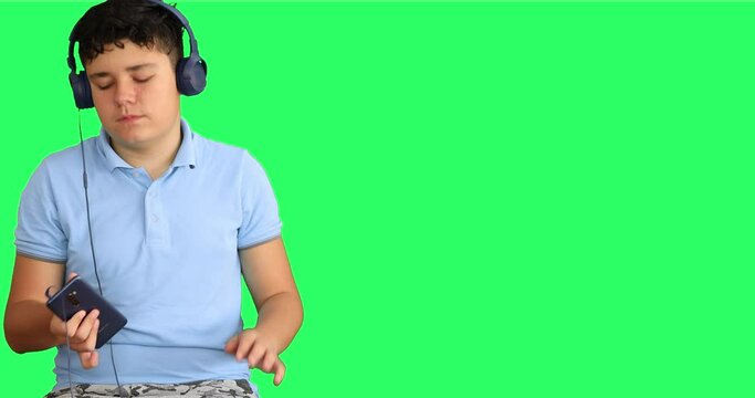 Happy teenager with headphone enjoy listen to music agains green secreen background