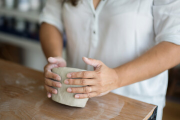 Woman kneading clay to make pottery