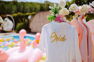 Beautiful white bathrobes for the bride and her bridesmaids hanging in the yard at a bachelorette...
