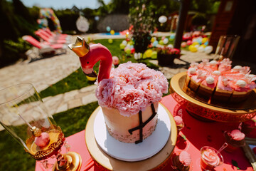 Cute pink table for a summer party in the yard. Pink cakes and treats on the table