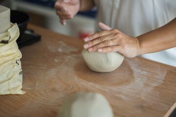 Woman kneading clay to make pottery
