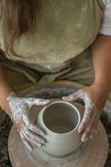 Woman making pottery on the wheel
