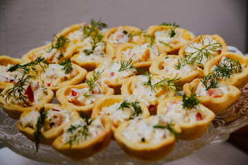 Small canapes sandwiches served on a plate at the celebration. Snack for guests