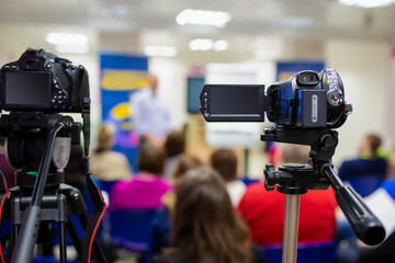 Front View of Professional Videocamera. Positioned Against Blurred Background