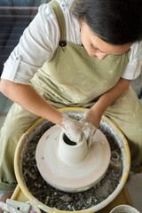 Woman making pottery on the wheel