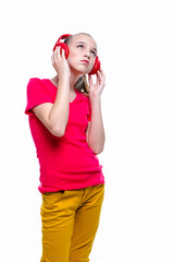 Portrait of Positive Caucasian Teenager Girl With Red Headphones Enjoying Music. Posing Against White.