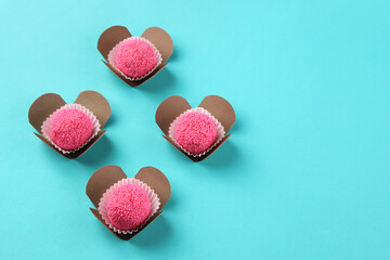 Strawberry candies forming hearts on blue background