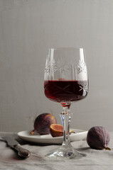 Glass wine with figs on the grey background.