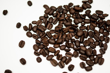 Roasted coffee beans against a white background.