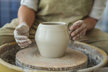Obraz na płótnie Canvas Woman making pottery on the wheel