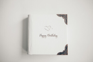 A white book wrapped in leather on a white background. photo album with a metal frame. Greeting card