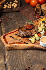 Beef steak with vegetables on the wooden board