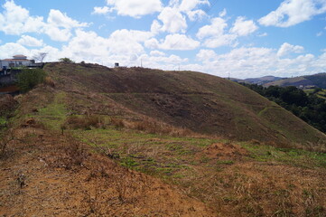 landscape mountain with lower green grass and clouds in a blue sky