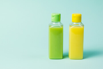 Yellow and green plastic bottles on a blue background.
