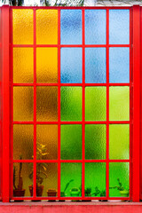 ventanal rojo con cristales de colores y plantas