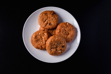 Cookies in a white plate on a black background