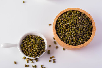 Green beans in a wooden cup on a white background