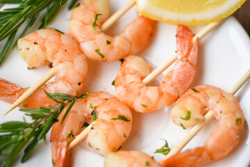 Salad grilled shrimp skewers delicious seasoning spices on white plate appetizing cooked shrimps baked prawns , Seafood shelfish with rosemary and lemon /