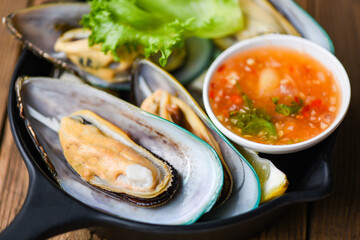 Fresh mussels on black bowl and seafood sauce shellfish steamed mussels /
