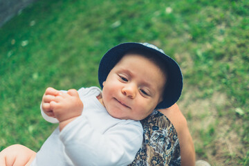 Baby lying in mother's lap outdoors