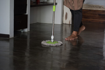 person cleaning floor with mop