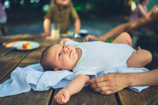Mother laying baby on table outdoors