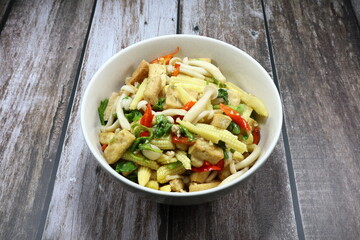 Traditional spicy fried and stirred sliced fresh baby corn, chopped dried tofu, chilly, mushroom and Chinese celery in the bowl. Famous vegetarian menu in Asia restaurant. 