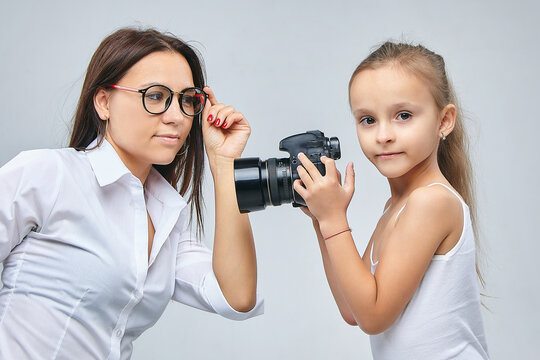 little girl takes pictures of her mother in the Studio