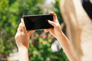 Traveler woman holding smartphone outdoors.