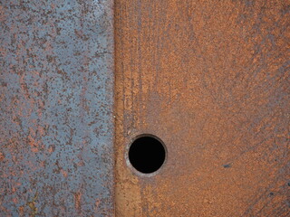 Rusty metal surface with a black hole