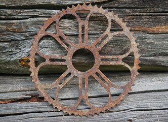Rusty gear wheel on an old wooden surface
