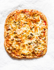 Delicious tapas, snack, appetizer. Canned tuna, tomatoes, mozzarella cheese pizza on a light background, top view