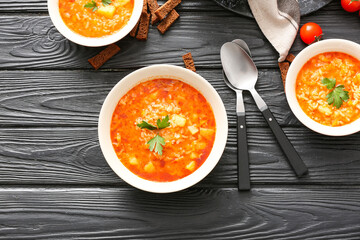Bowls of tasty rice soup on table