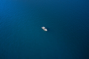 Aerial view of luxury ship at sunset, blue sea. Yacht at the sea in Europe. Top view from drone of yacht. High altitude air view