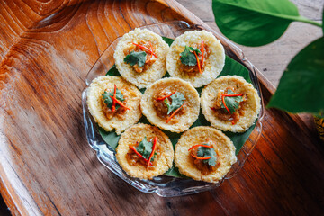 Crispy rice cake and pork and shrimp dipping in plate on wood table. thai food