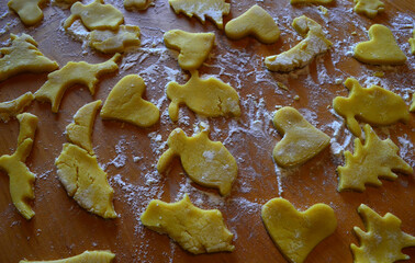 Shortbread cookies of different shapes on a wooden table with flour. Cooking, baking.