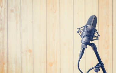 condenser microphone on wooden studio wall background